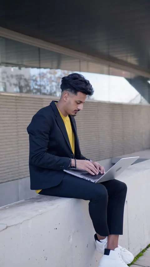 Moroccan freelancer typing on a laptop computer outdoors. Vertical Stock Footage 340170761
