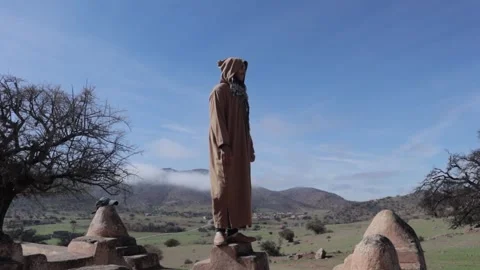 Moroccan Man in Djellaba Overlooking Mountain Landscape Stock-Footage 332771090