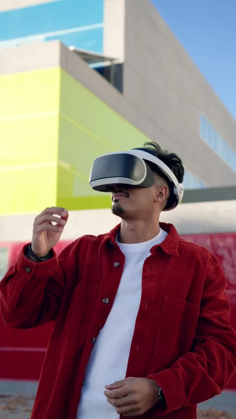 Moroccan man interacting with a virtual reality headset outdoors. Vertical Stock Footage 340170758