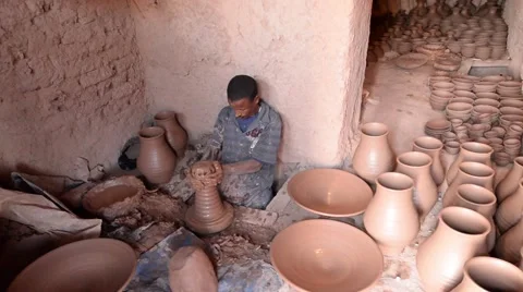 A Moroccan man manifacturing plates and pots of clay at Maison de poterie Stock Footage 49678601