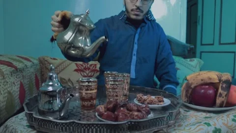 “Moroccan Man Pouring Mint Tea with Dates and Traditional Sweets” Stock Footage 303967796