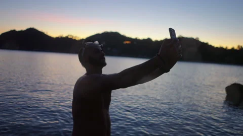 Moroccan man taking a selfie at sunset in a beautiful island in thailand Stock Footage 235268123