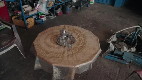 Moroccan silver teapot and tea glasses on round table inside rustic workshop Stock Footage 337914036