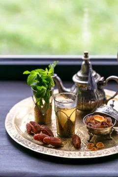 Moroccan tea with mint and sugar in a glasses on a copper plate with kettle Stock Photos