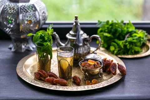 Moroccan tea with mint and sugar in a glasses on a copper plate with kettle Stock Photos