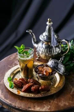 Moroccan tea with mint and sugar in a glass on a dark background Stock Photos