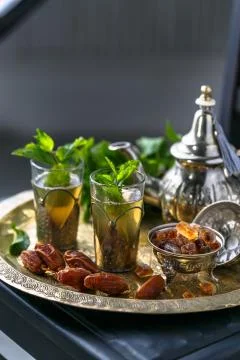 Moroccan tea with mint in traditional glasses, copper teapot on a copper plate Stock Photos