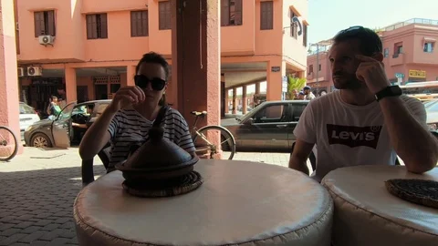 Moroccan waiter serving two tourists hot beef tajin Stock Footage 101443541