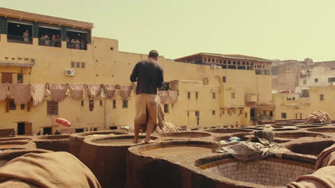 A Moroccan Worker Soaking Traditional Leather in the dye pool Stock Footage 271312442