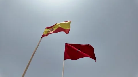 Morocco flag and Spain flag waving at a beautiful blue sky in Agadir Stock Footage 280197876