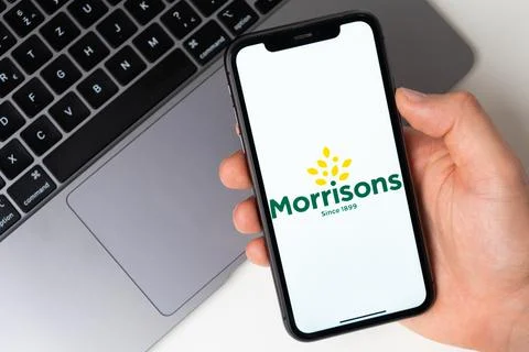 Morrisons the application is open in the smartphone. The man is holding a mobile 스톡 사진