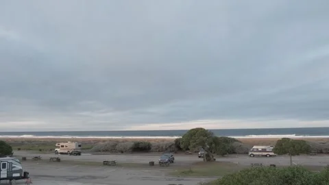 MORRO BAY, CA - DECEMBER 10, 2022 - RVs parked along beach under cloudy sky Stock Footage 345146484
