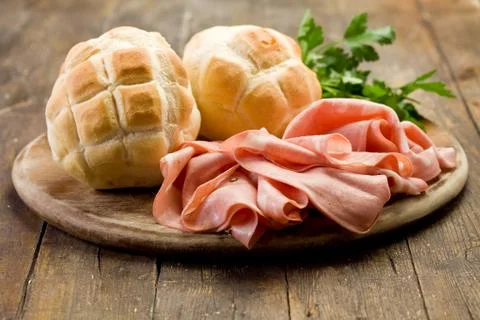 Mortadella with bread on chopping board Stock Photos