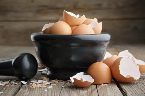 Mortar of eggshell. Shell of eggs on wooden kitchen table. Stock Photos