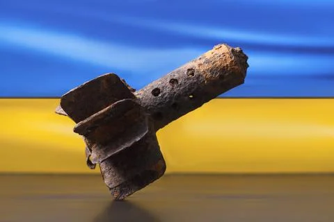 A mortar shell on the background of the blue - yellow flag of Ukraine Stock Photos