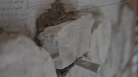 Mortar spread around edge of stone on wall 库存影片 339283918