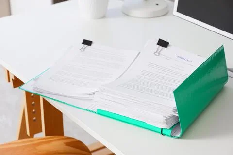 Mortgage documents in green folder on white desk, financial planning and real Stock Photos