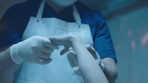 Mortician holding a hand of a cold body Stock Footage 283145853