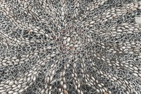 Mosaic ground pavement with radial pattern of black and white pebble stones Stock Photos
