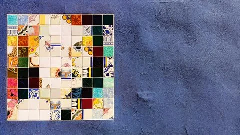 A mosaic with a pattern is assembled into a square and installed on a wall that Stock Photos