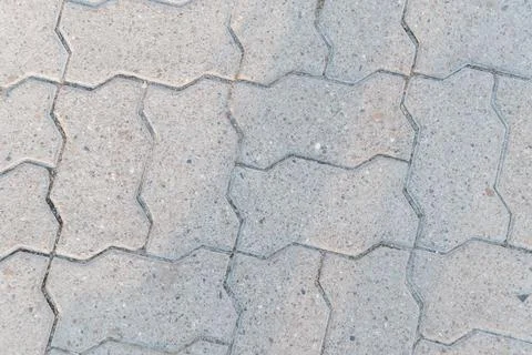 Mosaic Pattern of Interlocking Concrete Pavers in Soft Natural Light Stock Photos