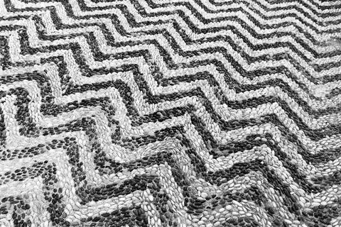 Mosaic pavement with striped pattern of black and white pebble stones Stock Photos