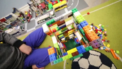 MOSCOW - DEC 5, 2016: Boy sits next to a tall tower of colorful Lego pieces, Stock Footage 84964339