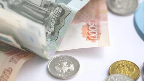 Moscow July 14 2024. A stack of bills and coins on a white background Stock Photos