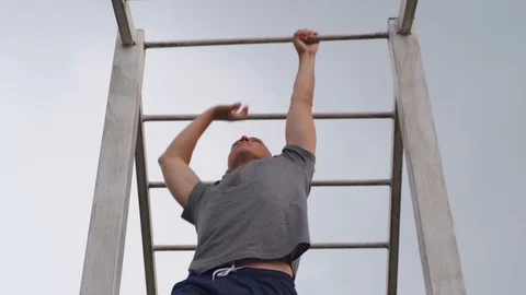 MOSCOW - JULY 28. Athletic guy doing hand ladder crossing on a horizontal bar in Stock Footage 123876947