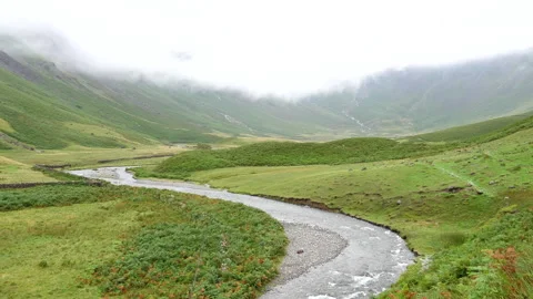 Mosedale Beck mountain stream in the valley under low clouds Vídeos de archivo 253990026