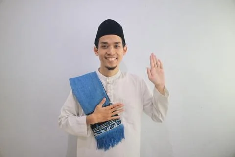 Moslem Asian man looking to the camera with happy face expression while wav.. Stock Photos