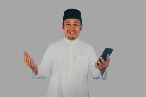 Moslem Asian man smiling happy when holding a mobile phone Stock Photos