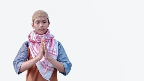 Moslem Asian teeneger smiling while doing hand praying gesture Stock Photos