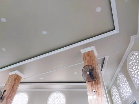 Mosque interior with ceiling fan and prayer space Stock Photos