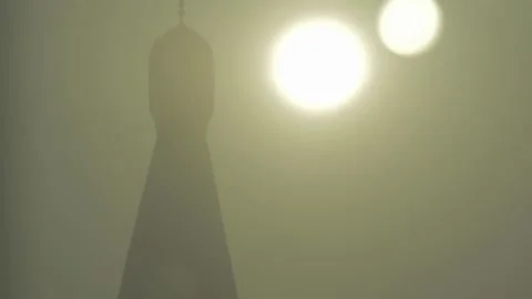 Mosque silhouette in sand storm with sun reflection camera tilting up Stock Footage 248892984