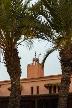 Mosque tower between two palm trees in Marrakesh, Morocco Stockfoto's