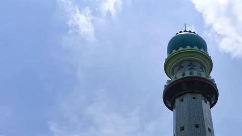 Mosque tower with green dome under clear blue sky. Magnificent mosque tower Stockfoto's