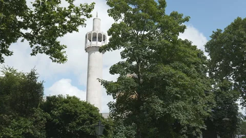 A mosque’s minaret seen through tree branches in summer. Stock Footage 246389224