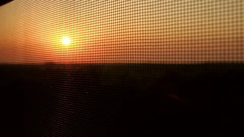 Mosquito net on window on a background of a sunset Stock Footage 86122353