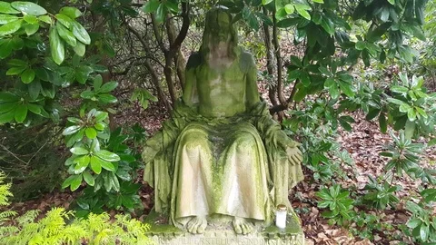 Moss covered statue of Jesus under tree, Schwerin cemetery, drizzle, Germany Stockbeeldmateriaal 76302889