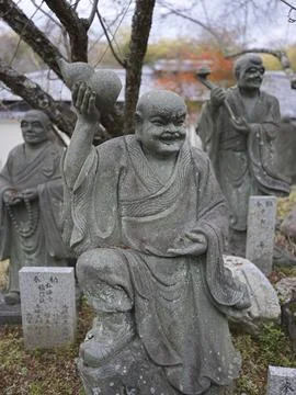 Moss-covered stone Buddhist statues in a temple forest, Japan Stock Photos