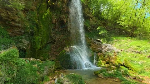 Moss covers rocks beside a gentle waterfall. Gostilje Waterfall, Serbia. Stock-Footage 337060356