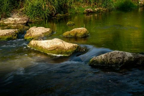 Mossy Rocks in Gentle Stream Stock Photos