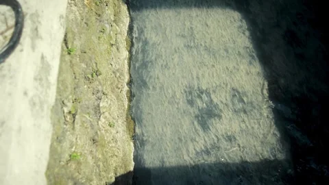 Mossy Stone Drainage Channel Edge With Subtle Water Movement Under Soft Sun.. Stock Footage 340453057