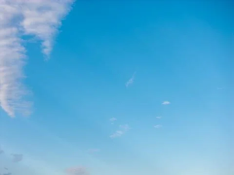 Mostly clear deep blue sky with a single wispy cloud trailing along the left Stockfoto's