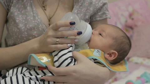The mothe feeds his son from a bottle. Stock Footage 99757205