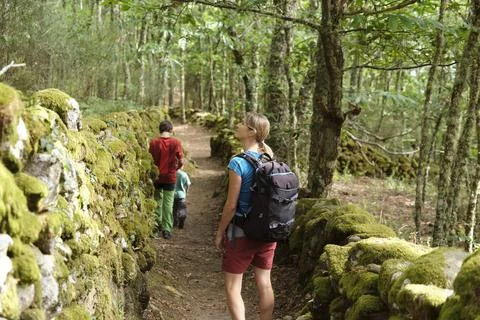 Mother admiring the forest while walking with her children Foto stock