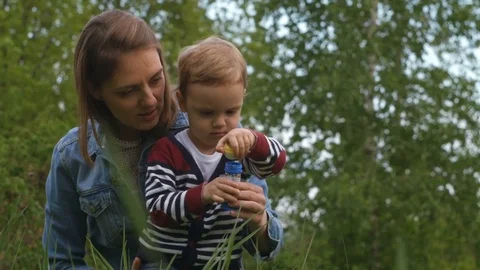 Mother and baby blowing soap bubble outdoors Stock Footage