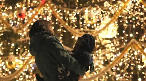 Mother and baby dancing in night near Christmas tree with lights Stock Footage