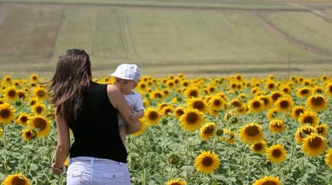 Mother and baby near sunflower field Stock Footage